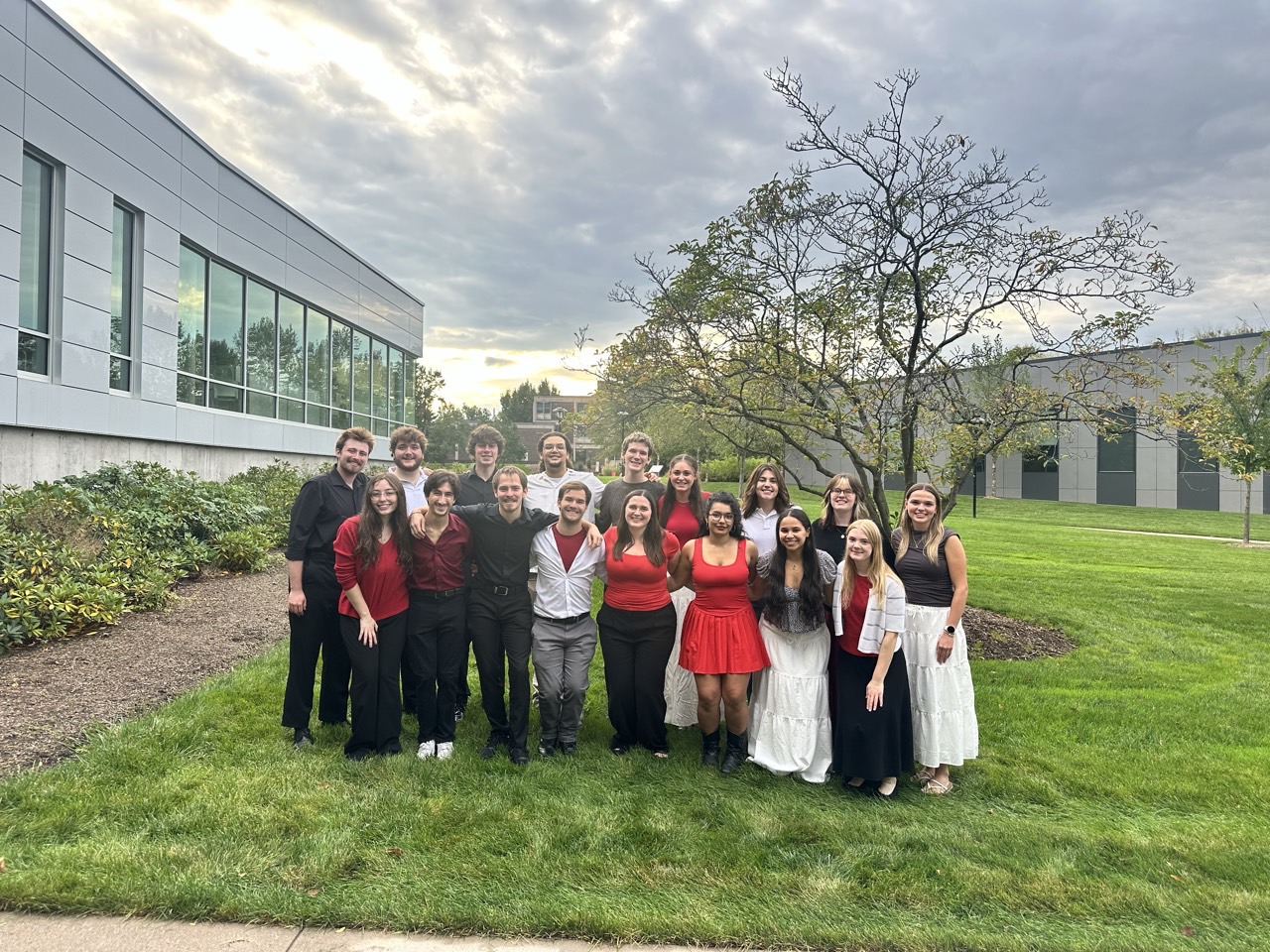 Members of L’Shir A Cappella posing together on a lawn