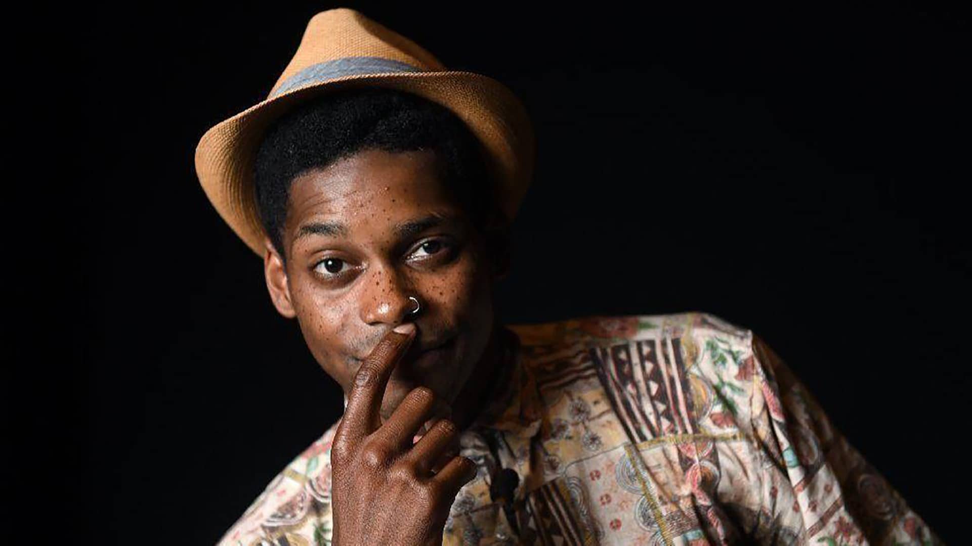 Tang Sauce in a straw fedora against a black background
