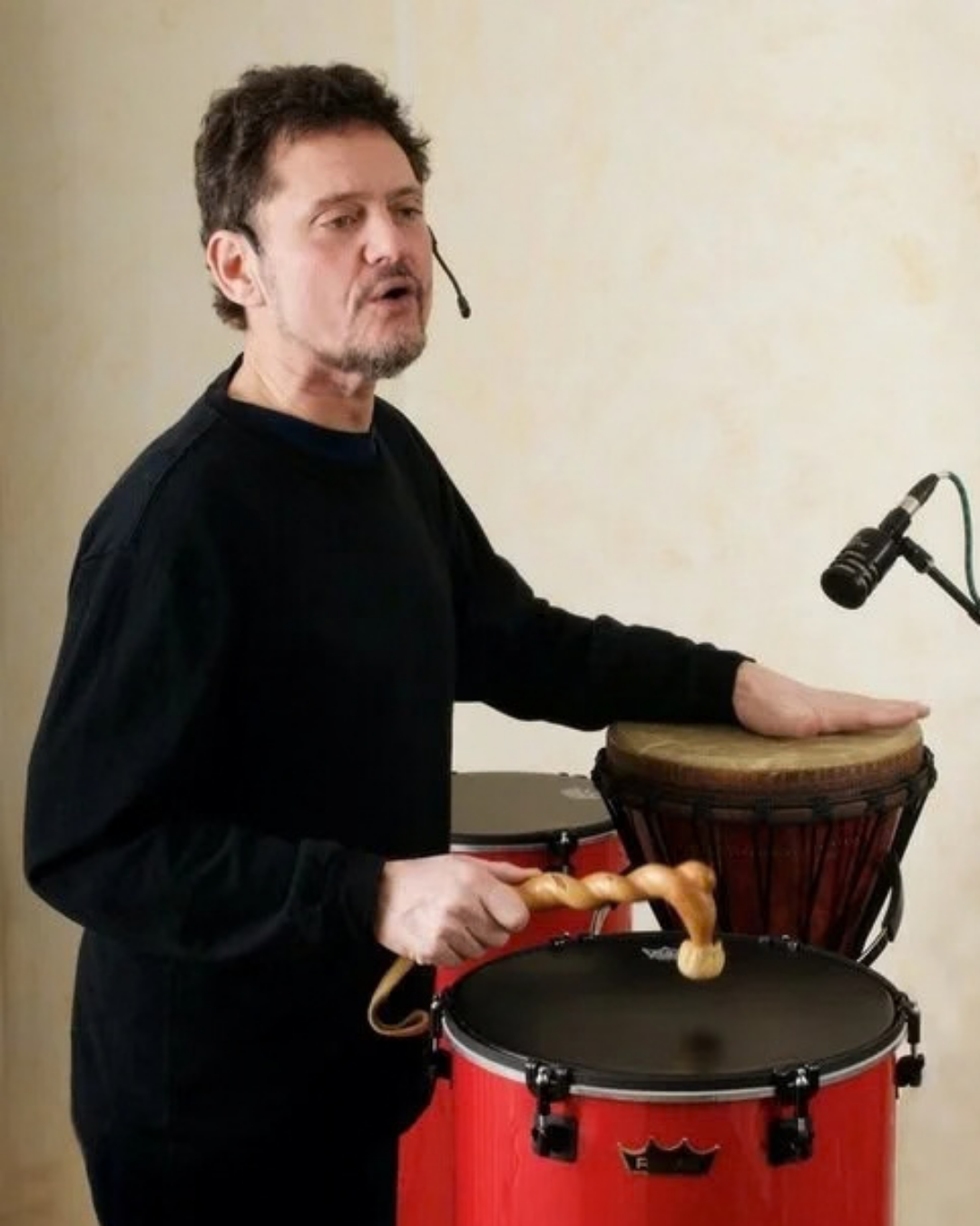 Bob Bloom drumming and singing with a headset microphone