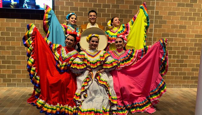 Ballet Folklórico dancers posing in colorful ruffled skirts